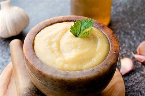Mortero con ajo y aceite para preparar alioli tradicional
