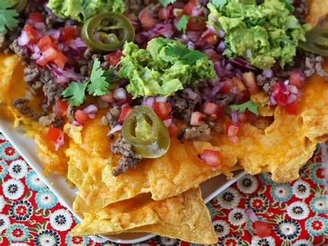 Plato de nachos con queso, guacamole y chili con carne
