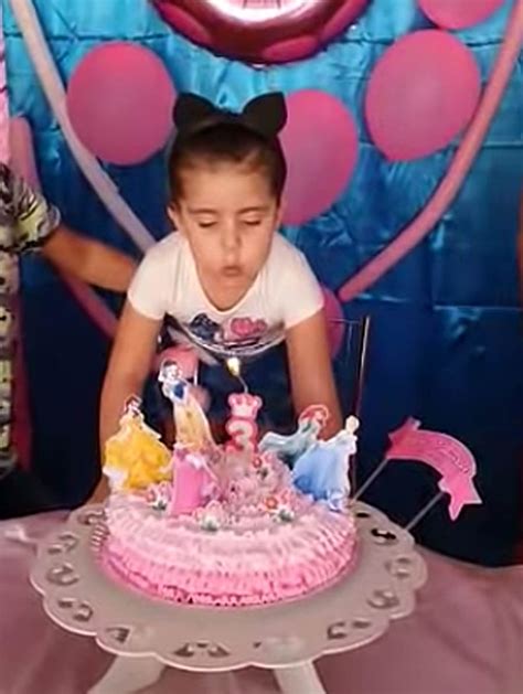 María Antonia soplando la vela del pastel de María Eduarda