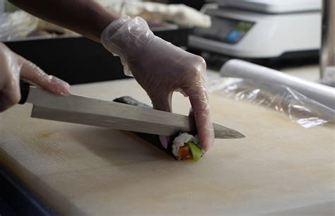 Chef profesional enseñando a cortar pescado para sushi