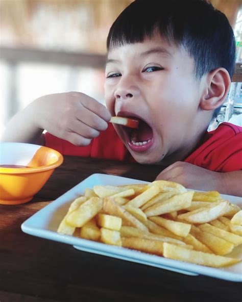Niño comiendo patatas fritas sin sal