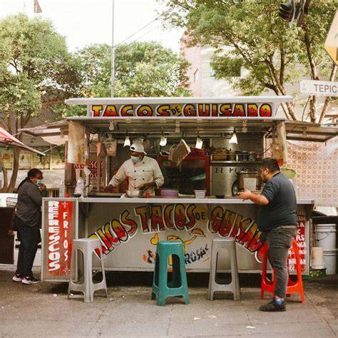 Puesto callejero de comida en la Ciudad de México con tamales y atole