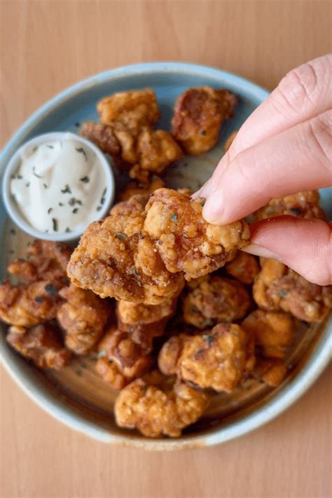 Primer plano de palomitas de pollo crujientes con diferentes salsas