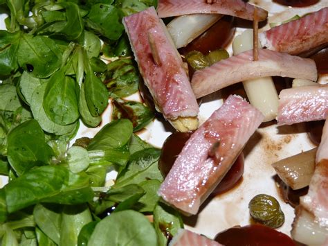 Plato de anguila ahumada con tostadas y alcaparras