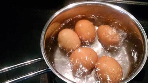 Huevos cociéndose en un cazo con vinagre
