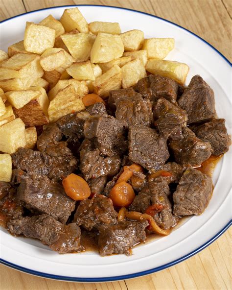 Mesa con plato de ternera guisada y pan