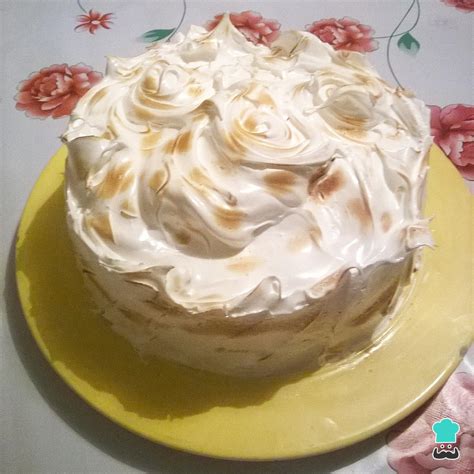 Torta tres leches decorada con merengue y cerezas