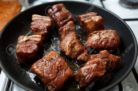 Costillas de cerdo dorándose en sartén