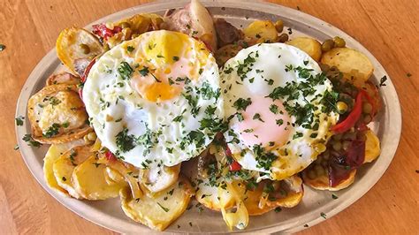 Costillas de cerdo a la riojana servidas con huevos fritos y papas