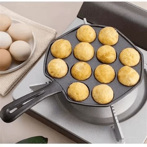 Sartén especial para takoyaki con las bolitas cocinándose