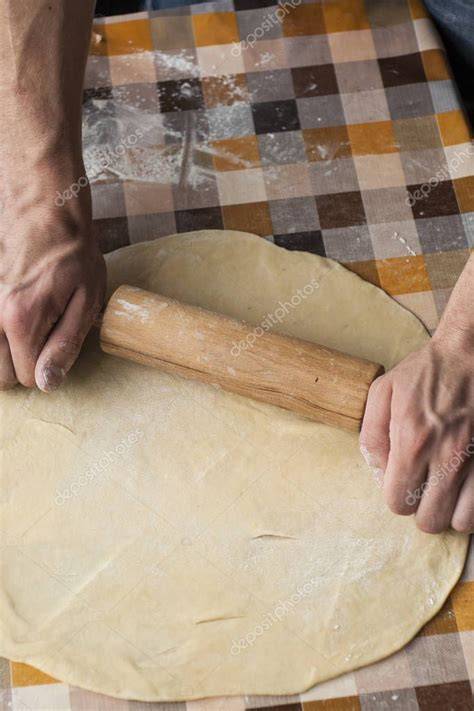 primer plano de un pizzaiolo amasando masa