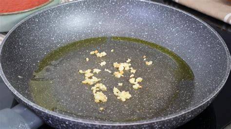 Ajos dorándose en aceite para la receta de conejo