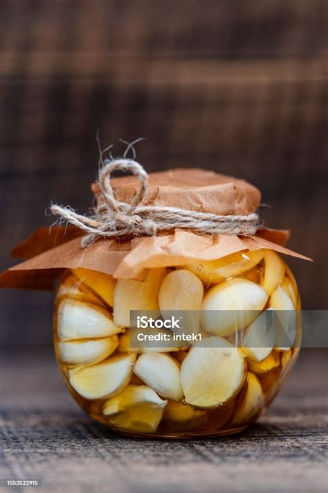 Frasco de vidrio con dientes de ajo en miel
