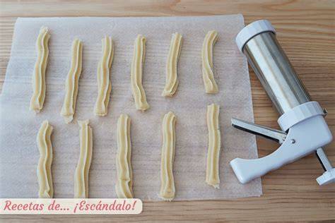 formando churros con churrera sobre papel vegetal