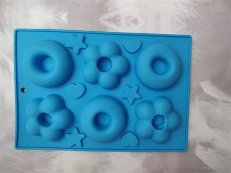 Diferentes tipos de moldes de silicona con chocolates de colores terminados
