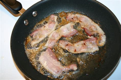 Chorizo y tocino friéndose en un sartén