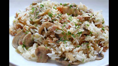 Arroz con pollo y champiñones en sartén de acero inoxidable