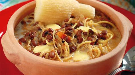 plato servido de caldo de poroto con carne y tomatitos