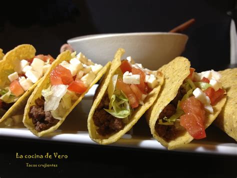 Tacos crujientes servidos con queso y vegetales frescos