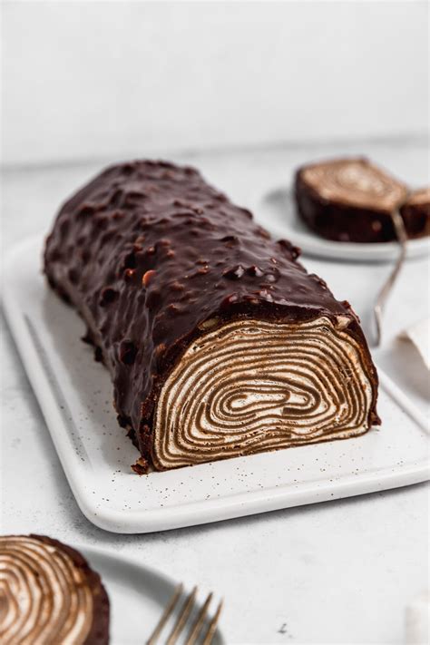 Rollo de crepes de chocolate con crema batida y frutas