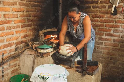 Mujer preparando tortillas con una prensa