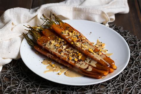 Zanahorias glaseadas en un plato con salsa de tahini