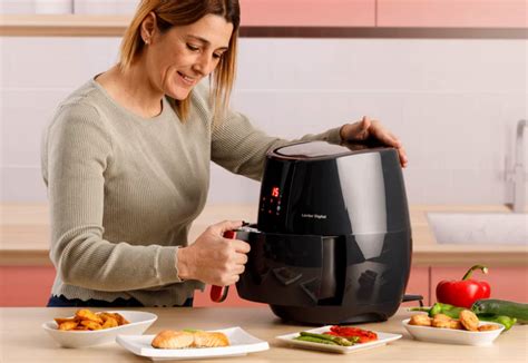 Persona utilizando una freidora de aire para cocinar