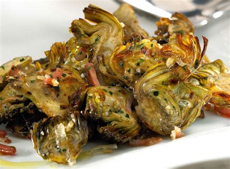 Plato de tiras de calamar salteadas con corazones de alcachofas y crujiente de bacon
