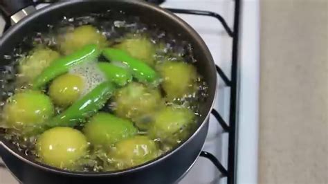 Olla con tomates verdes hirviendo lentamente