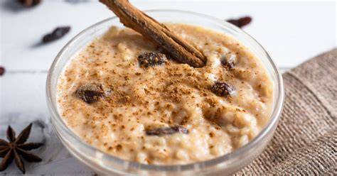 Tazón de arroz con leche cremoso con virutas de chocolate blanco y canela