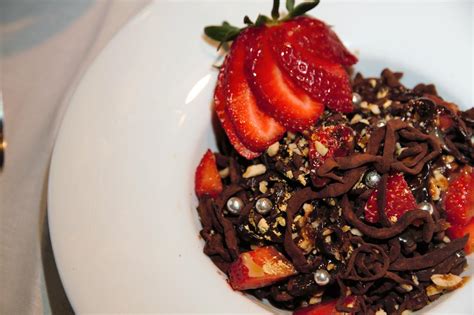 Plato de espaguetis de chocolate con frutas y sirope