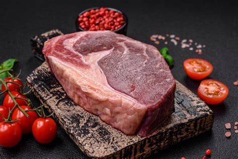 Lomo de ternera crudo atado con hilo de cocina, untado con mostaza en grano