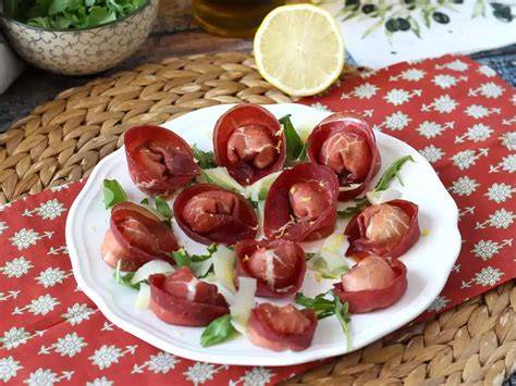 Presentación de bresaola en un plato con rúcula y parmesano