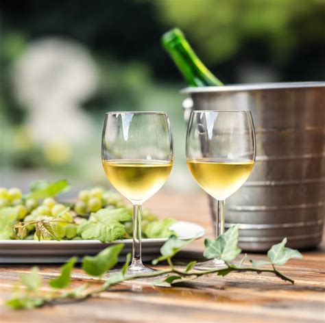Vino blanco en una copa y distintos ingredientes culinarios