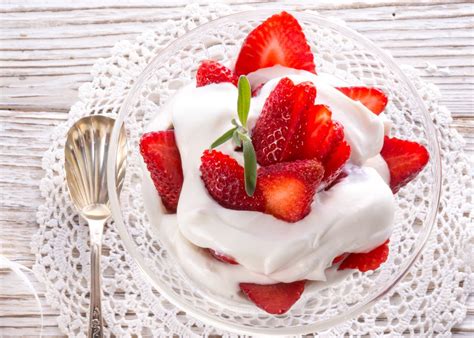 Plato de tortitas con sirope de fresa, nata montada y fresas frescas