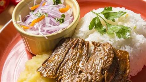 Plato de carne frita con puré de papas y bayas molidas