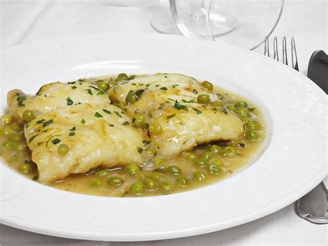 Plato terminado de merluza con mejillones y guisantes