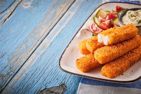 Plato de varitas de merluza doradas y crujientes servidas con salsa