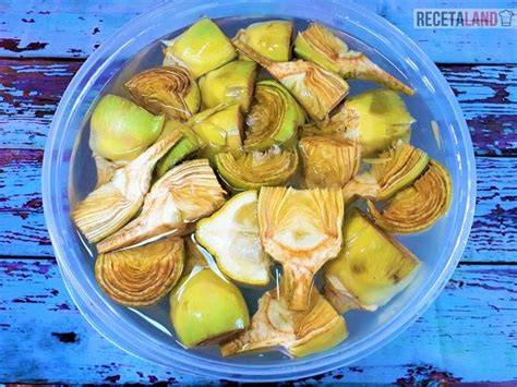 Alcachofas cortadas en agua con limón y perejil