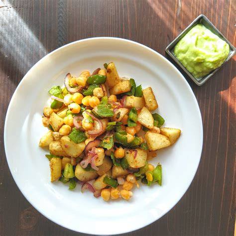 Plato de patatas asadas con verduras, garbanzos y alioli de aguacate