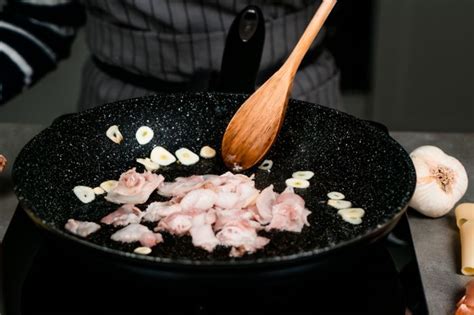 Ajo laminado y cebolla pochándose en una sartén