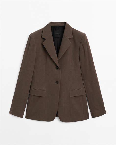 Mujer con blazer marrón chocolate y vaqueros
