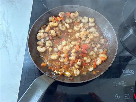 Gambas añadiéndose al sofrito en el wok