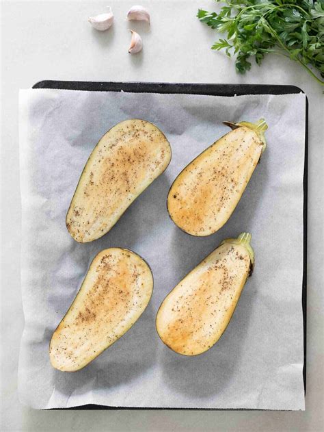 Berenjenas cortadas por la mitad y preparadas para hornear