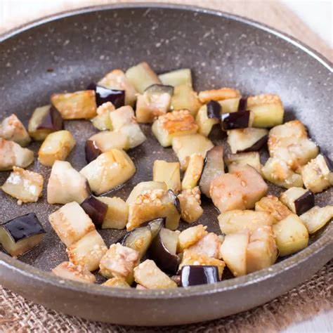 Mezcla de cebolla, jamón y carne de berenjena en una sartén