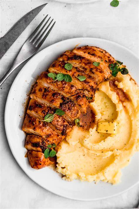 Plato de pechuga de pollo al horno con puré de papa y guarnición