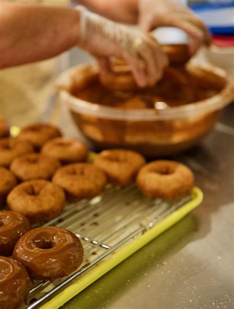 Proceso de baño de donuts en chocolate derretido
