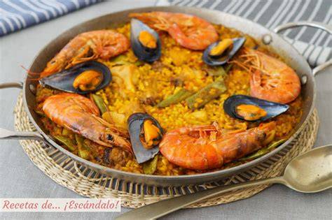 Mesa con una paella de gambón y ajos tiernos