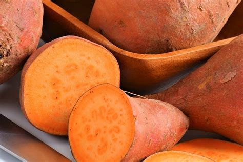 Tubérculos de boniato o camotes, de carne naranja, expuestos en un mercado local