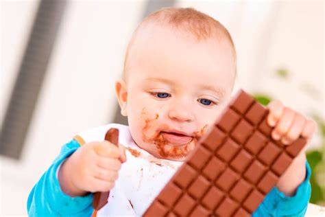 Bebé comiendo chocolate por primera vez